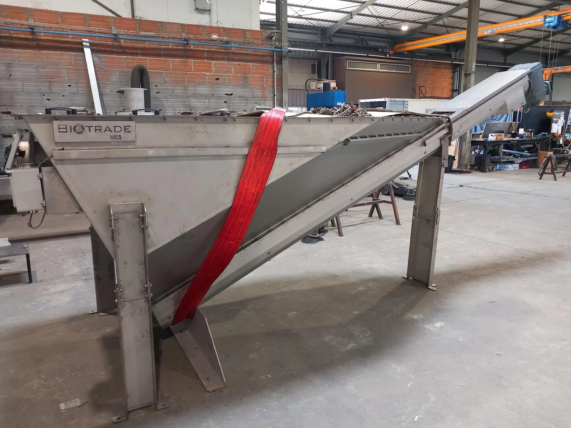 Classificateur à sable VES Biotrade avec logo visible en atelier de fabrication, vis de convoyage inclinée et caisson inox sur structure de support