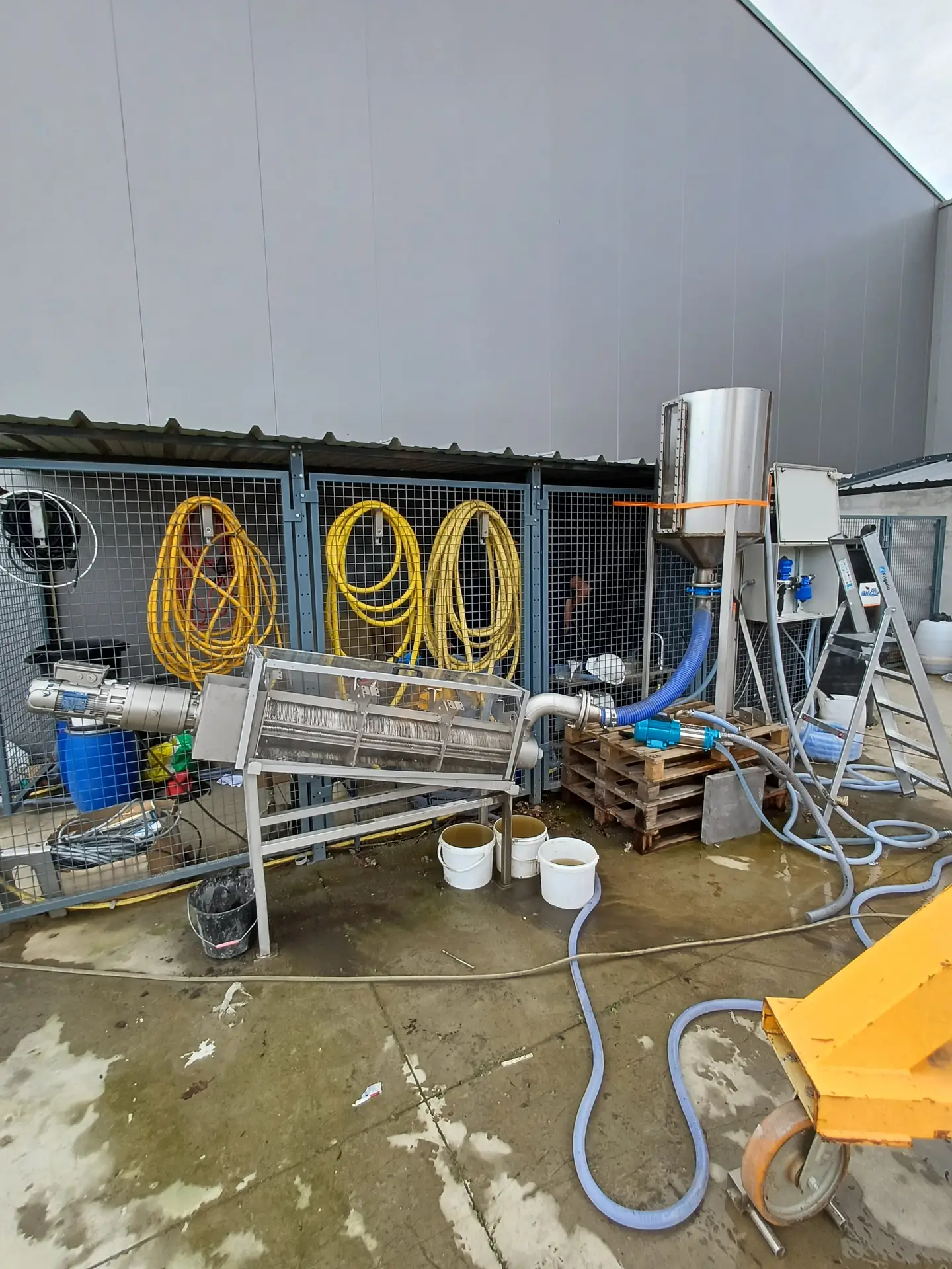Test de performance en extérieur d'une presse à vis et d'un système de préparation de polymère Biotrade, avec tuyauteries et seaux de boues
