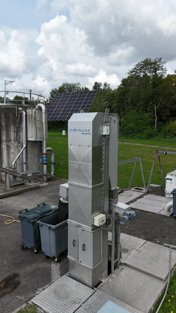 Dégrilleur BioScreen DS Biotrade installé en extérieur sur une station d'épuration, avec panneau solaire et ouvrage de béton en arrière-plan